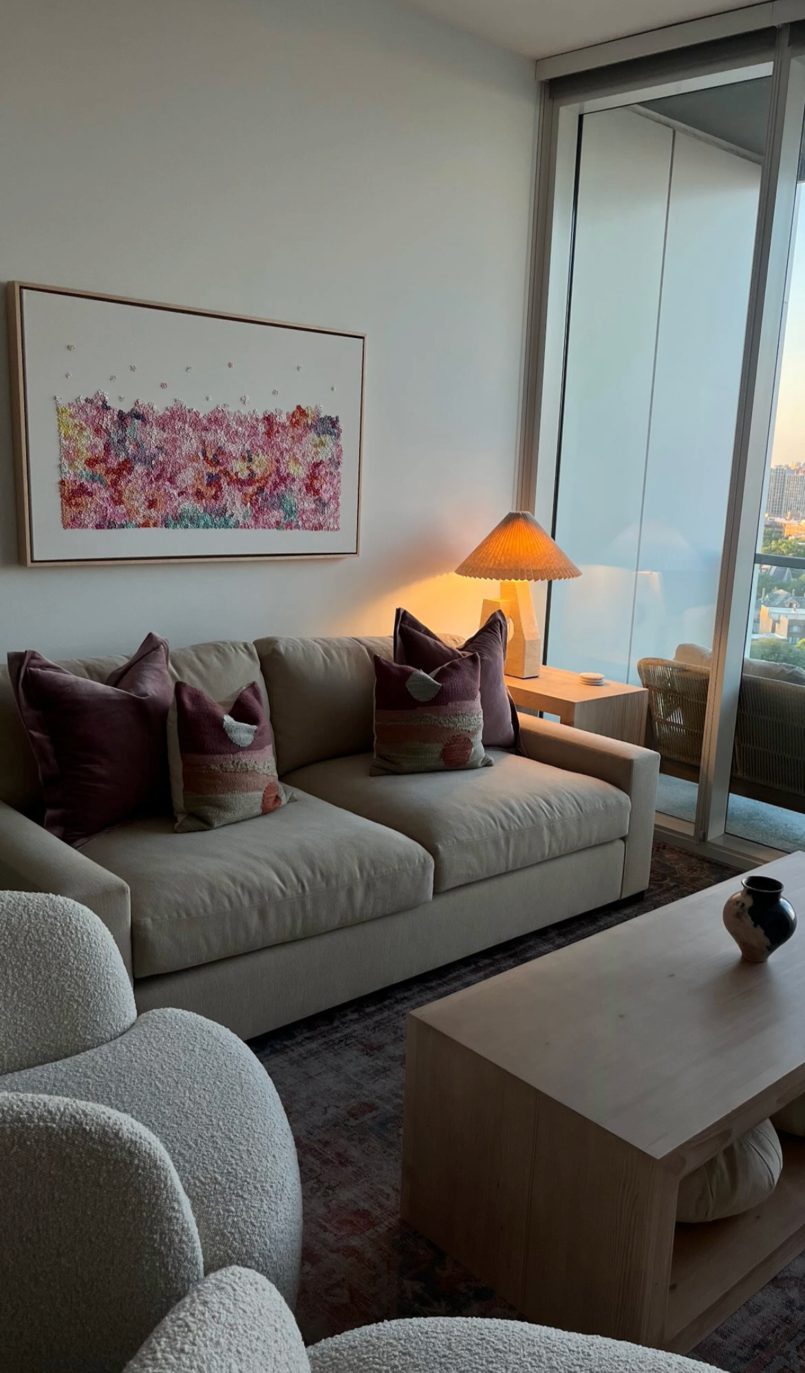 Living room with beige sofa, decorative pillows, and a large window.